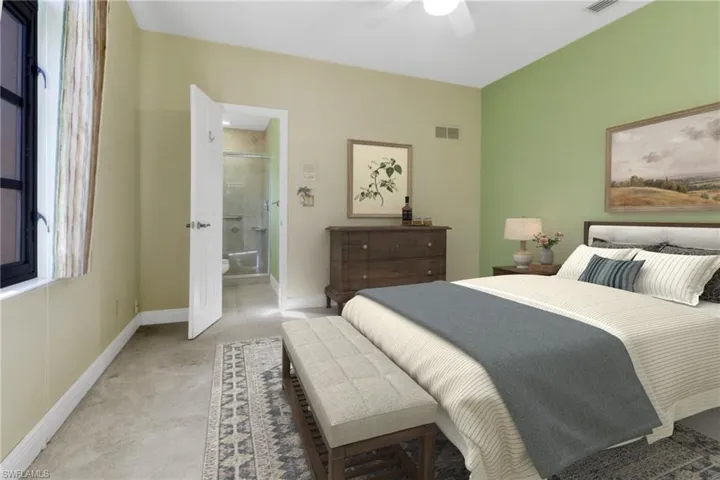 Carpeted bedroom with ensuite bathroom and ceiling fan
