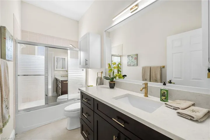 2nd full bathroom featuring new coffee color vanity, tile patterned floors, enclosed tub / shower