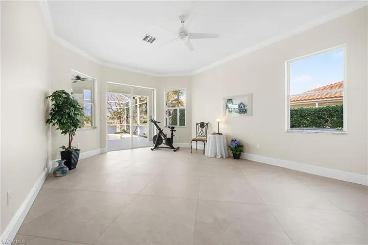 Exercise area featuring crown molding, ceiling fan, and light tile patterned floors