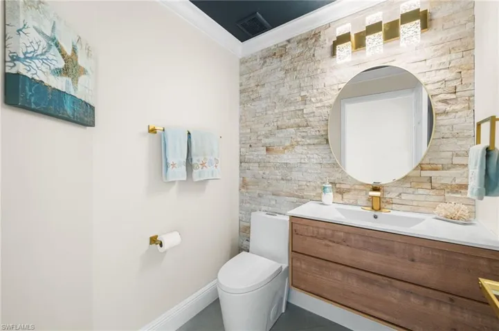 Guest bathroom with crown molding, floating vanity, custom stone wall and all new fixtures