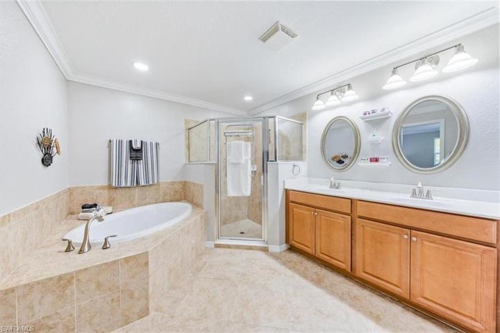Main bathroom with dual sinks, soaker tub, and large shower