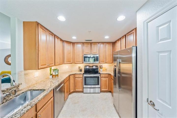 Kitchen with large pantry, granite counters, and stainless steel appliances