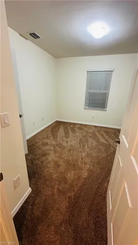 Spare room featuring carpet and baseboards