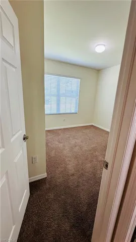 Carpeted empty room with baseboards