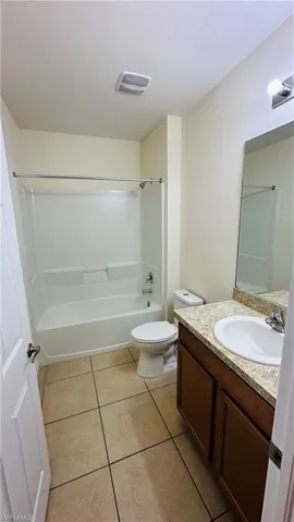Bathroom with tile patterned floors, vanity, and shower / washtub combination