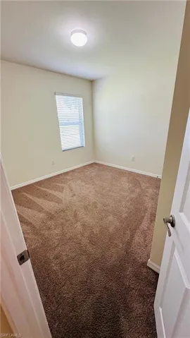 Unfurnished room featuring carpet floors and baseboards