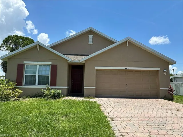 Single story home featuring stucco siding, decorative driveway, a garage, and a front lawn