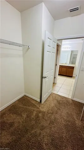Walk in closet featuring light colored carpet and light tile patterned flooring