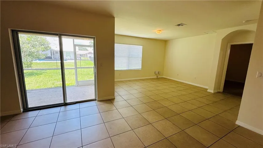 Unfurnished room with arched walkways and light tile patterned floors