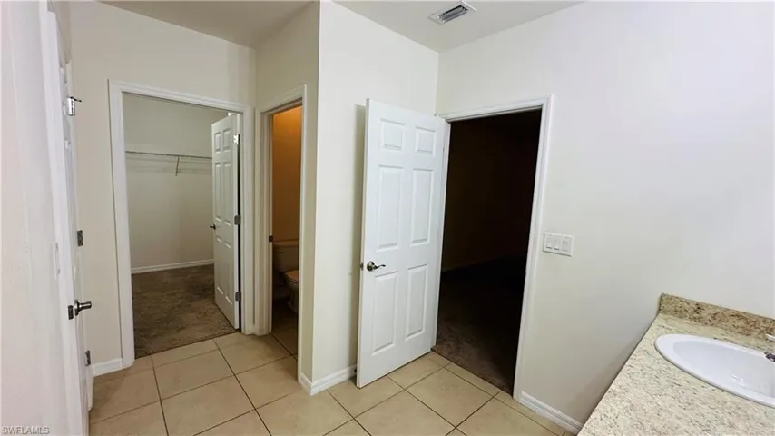 Bathroom with tile patterned floors, vanity, and a spacious closet