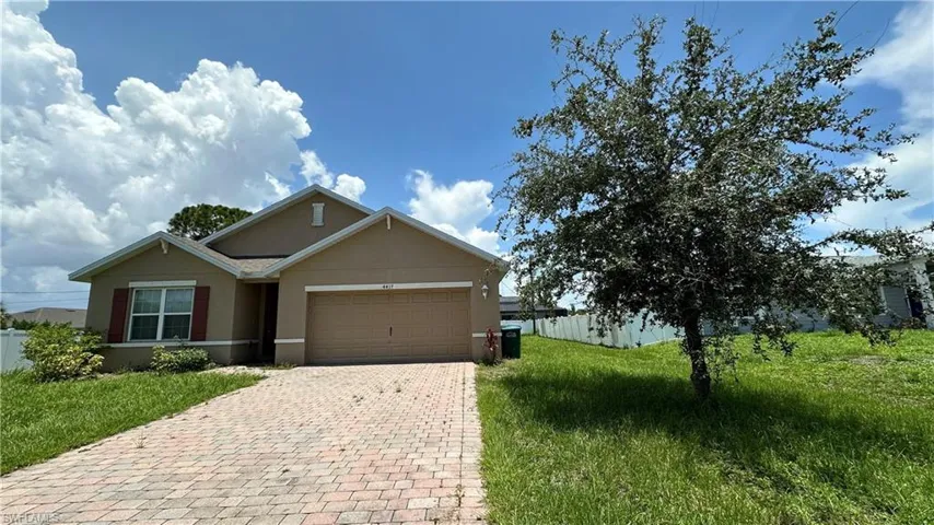 Ranch-style house with stucco siding, decorative driveway, and a garage
