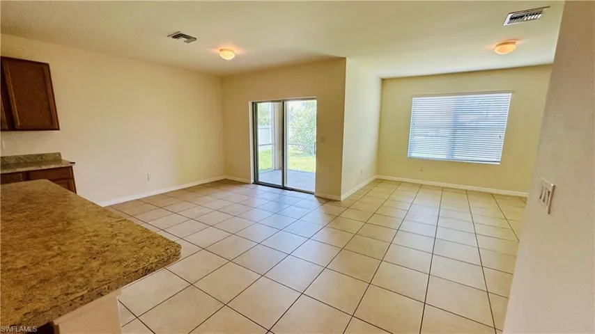 Unfurnished dining area featuring light tile patterned floors and baseboards