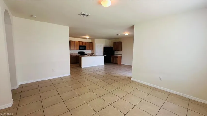 Unfurnished living room with baseboards and light tile patterned floors