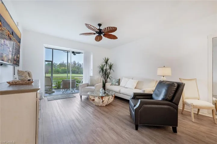 Living room with ceiling fan and light hardwood / wood-style flooring