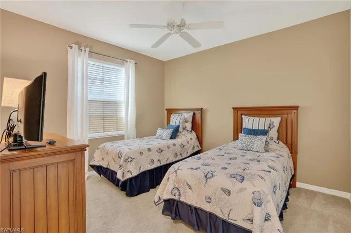 Carpeted bedroom featuring baseboards and ceiling fan