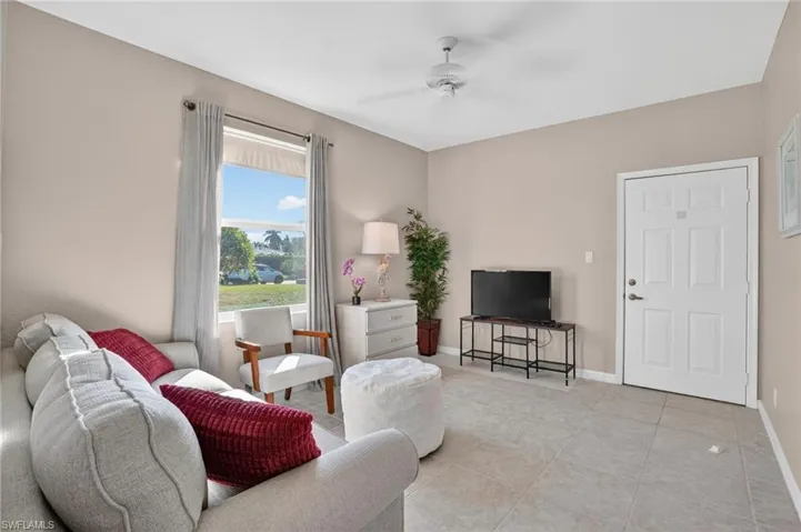 Living area with a ceiling fan and light tile patterned floors
