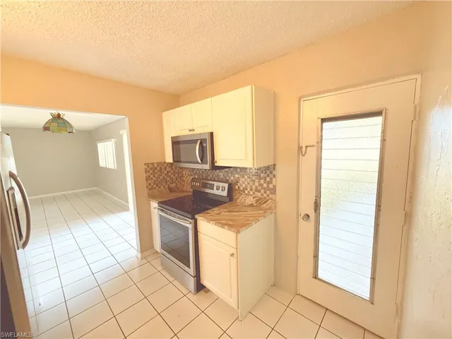 Kitchen with tile flooring and a patterned backsplash