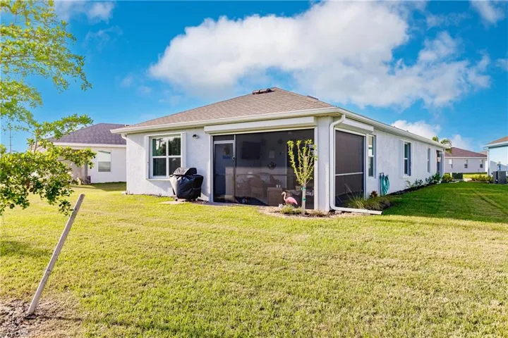 Back of house featuring a lawn and a sunroom