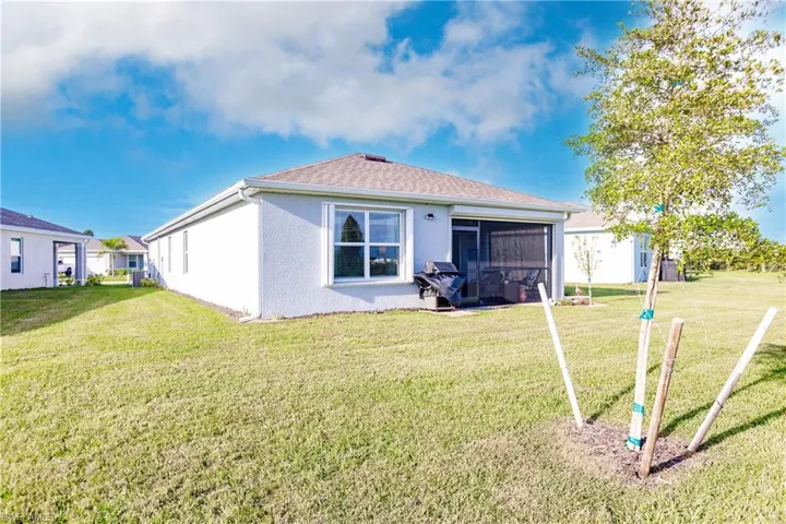 Back of property with a lawn and a sunroom