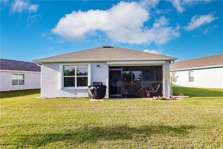 Rear view of property with a yard