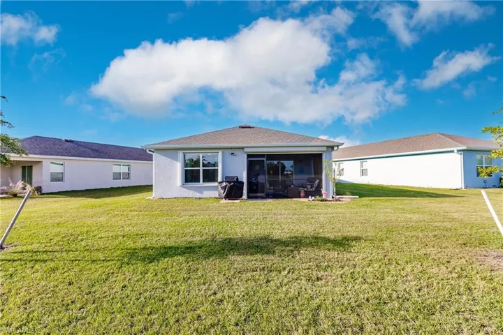 Back of property with a sunroom and a yard