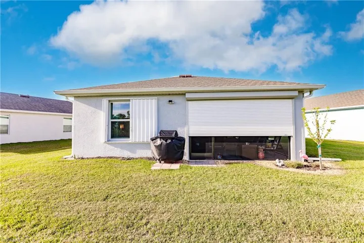 Back of property featuring a lawn