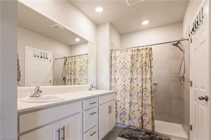 Primary Bathroom featuring a shower and dual vanity