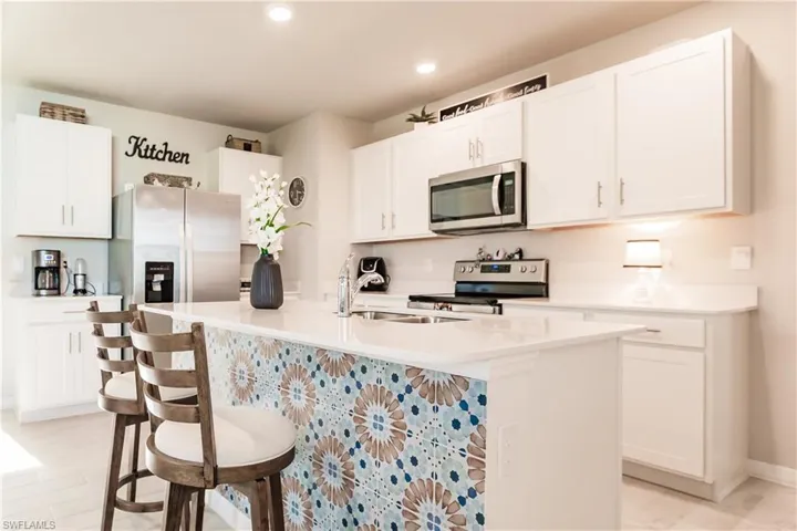 Kitchen featuring a bar and white cabinetry