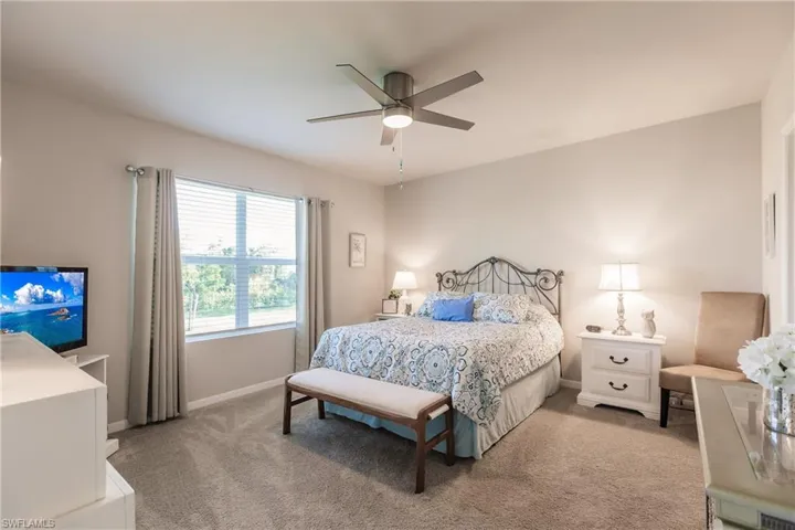 Carpeted primary bedroom featuring ceiling fan