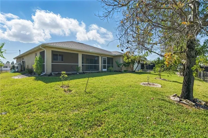 Rear view of house, back yard is fenced in.