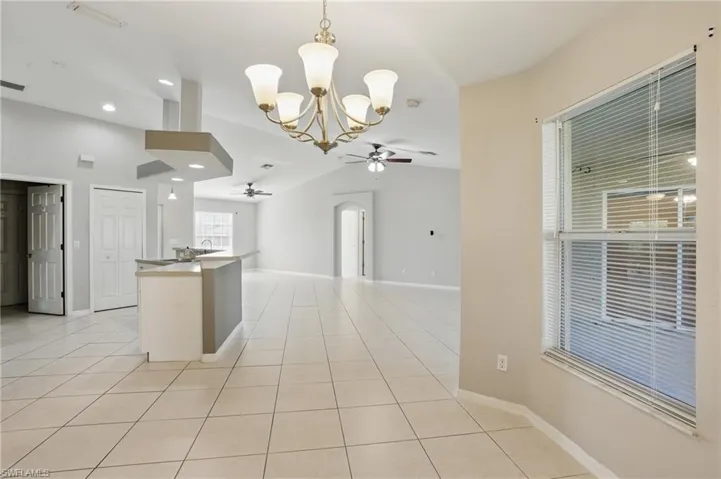 Kitchen featuring open floor plan, ceiling fan with pendant lighting, and lofted ceiling