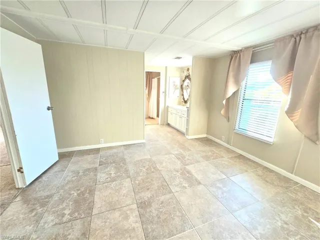 Unfurnished room with wooden walls and baseboards