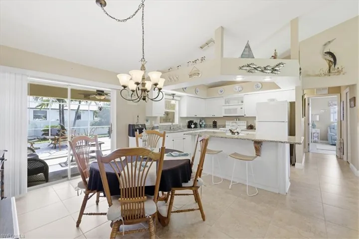 Dining space featuring lofted ceiling, a chandelier, and light tile patterned floors