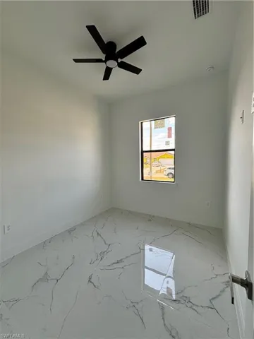 Unfurnished room featuring visible vents, baseboards, marble finish floor, and ceiling fan