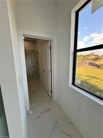Hallway featuring baseboards and marble finish floor