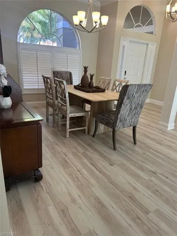Dining area featuring a chandelier, light wood-type flooring, and crown molding