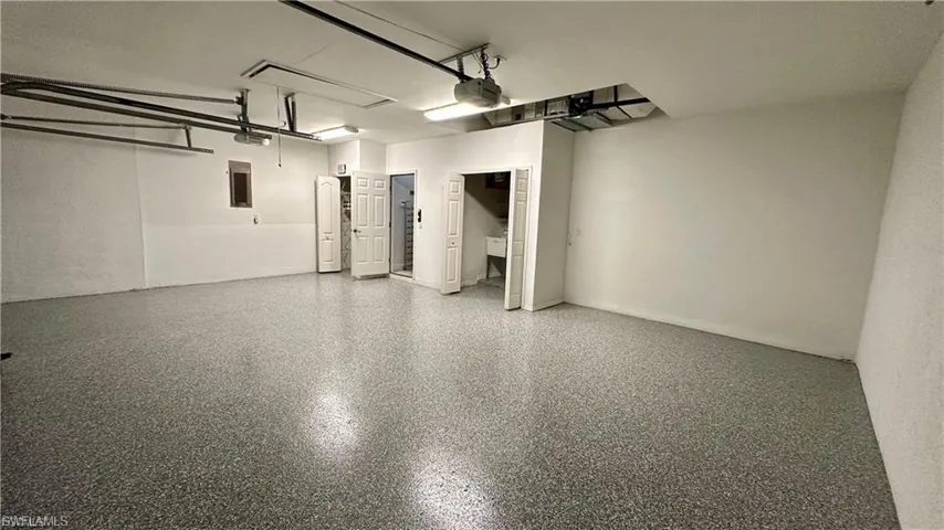 Garage with electric panel and a garage door opener