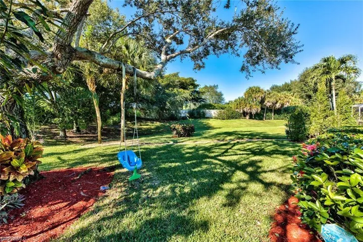 View of green lawn featuring view of scattered trees