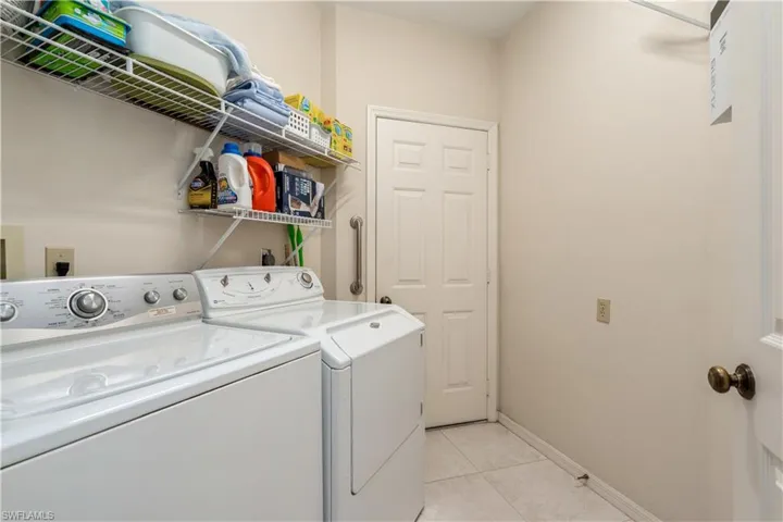 Laundry room with washer and dryer and light tile patterned floors