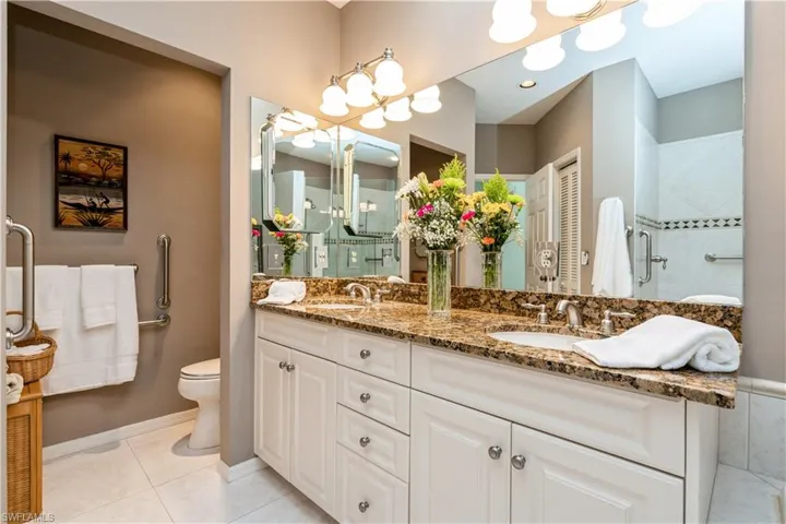 Primary bathroom with tile patterned flooring, vanity, toilet, and a shower with shower door