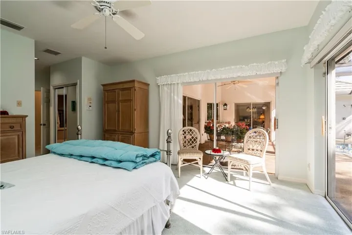 Primary carpeted bedroom with ceiling fan