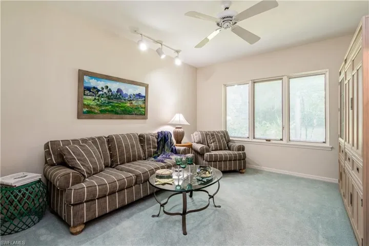 Den with ceiling fan and track lighting