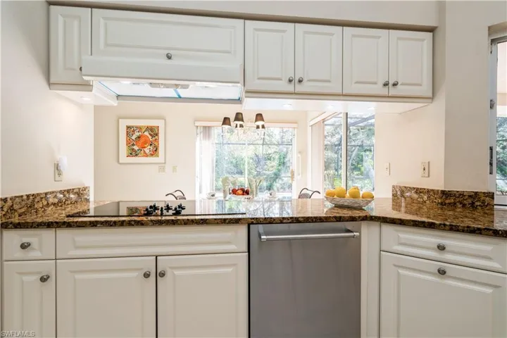 Kitchen with dishwasher, off white cabinets, and black electric cooktop