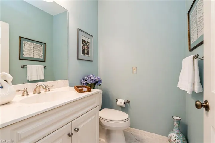 Powder room with vanity, tile patterned floors, and toilet
