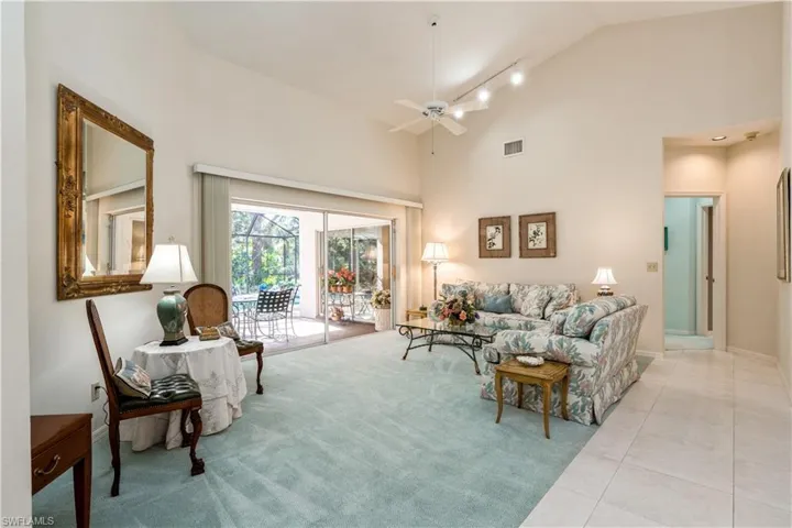 Living room featuring ceiling fan, light tile patterned floors, and high vaulted ceiling