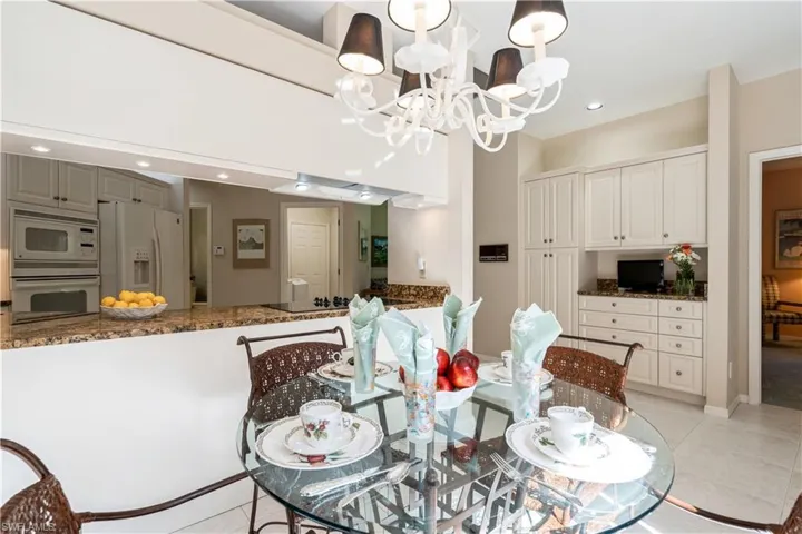 Tiled kitchen area featuring a notable chandelier