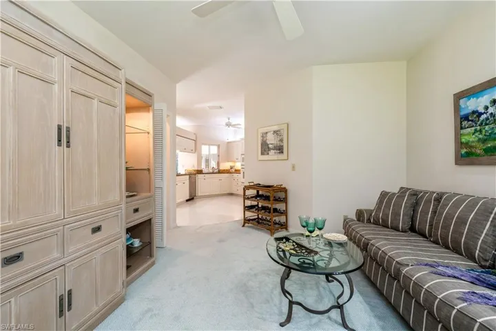 Den with dry bar featuring ceiling fan