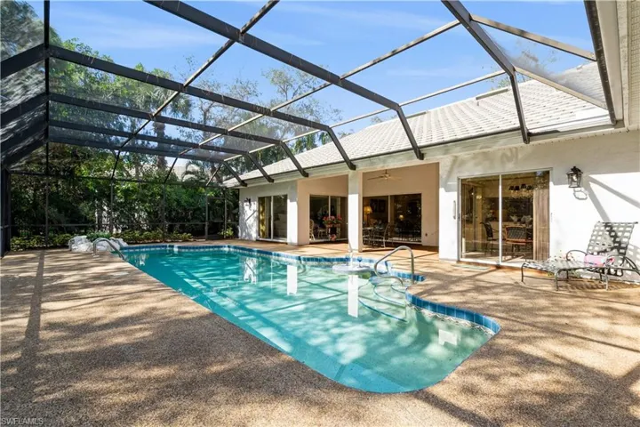 View of pool featuring pool water feature, ceiling fan, a lanai, and a patio