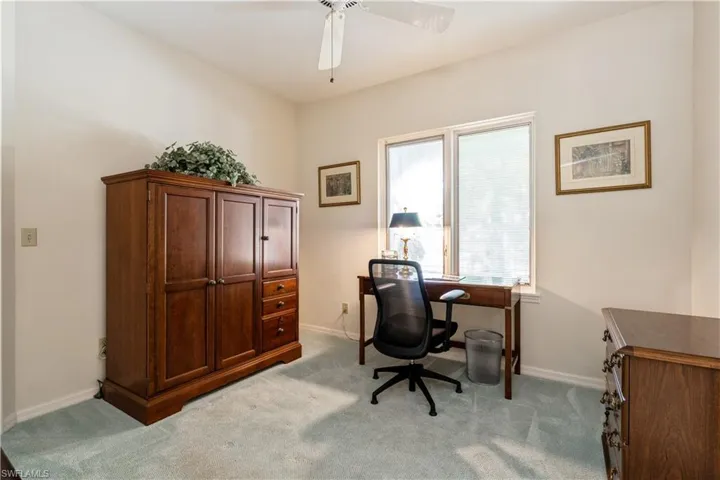 Office with ceiling fan and light colored carpet