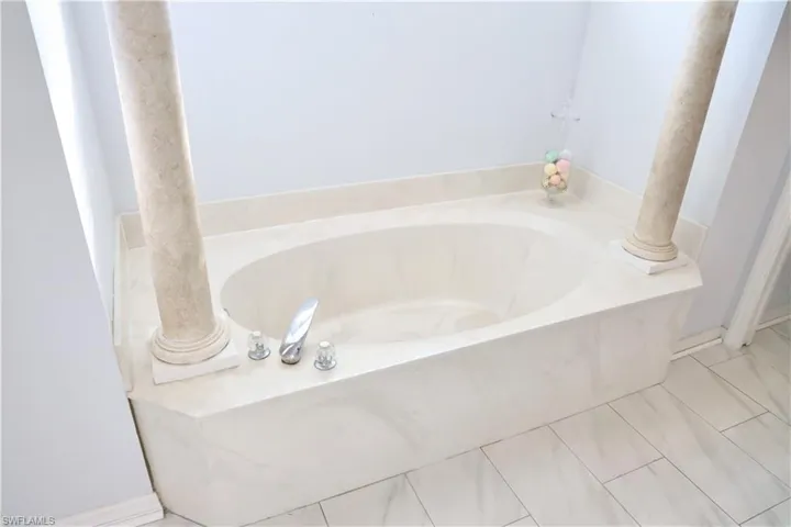 En-Suite Bathroom featuring tile patterned floors and a bath